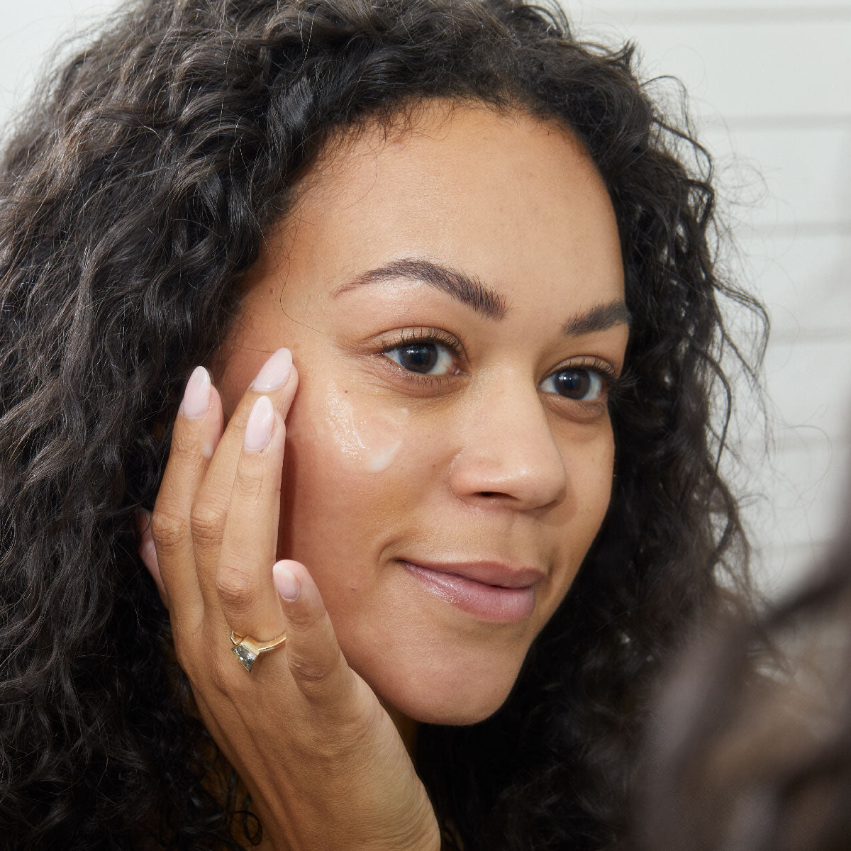 woman applying skincare with moisturizer